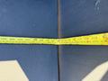 A measuring tape laid across a surface showing various measurements and a highlighted section at approximately 112 inches