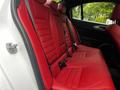 The image shows the interior of a 2023 Alfa Romeo Giulia featuring red leather seats in the back row with a sleek and modern design