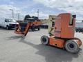 A 2009 JLG E300AJP aerial work platform with orange and beige colors featuring a raised platform and extended arm for reaching high areas