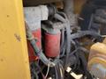 Close-up of the hydraulic system of a 2010 Vermeer Corporation BC1200XL featuring two red filters and various hoses connected to the engine components