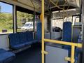 Interior of a 2016 Grande West Vicinity bus featuring blue upholstered seats and yellow handrails with the driver's area visible at the front