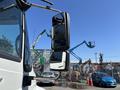 A 2011 International 4300 truck with prominent side mirrors reflecting the surrounding equipment and structures