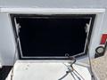 A large, empty storage compartment with a metal frame and two supporting cables on a 2017 Ford F-550