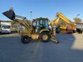 A yellow 2007 Komatsu WB156PS-5 backhoe loader with a front loader attachment and a rear excavator arm positioned for operation