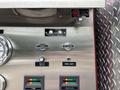 Control panel of a 2002 GMC C7500 featuring switches and gauges for various functions like heat exchanger and water level indicators