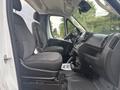 Interior view of a 2023 RAM Promaster 3500 featuring two gray fabric front seats and a black dashboard with controls and a central console