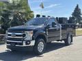 A 2022 Ford F-350 SD truck with a black body and a silver toolbox in the bed prominently displayed