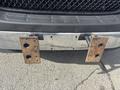 A 2018 Chevrolet Express with a chrome front bumper displaying rusted mounting brackets and a missing license plate
