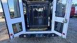 The rear view of a 2021 Ford Transit van with large double doors open revealing a lift platform inside