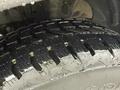 Close-up of a wet tire tread on a 2023 Ford Transit showcasing deep grooves and a robust design for traction