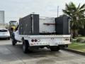 A 2015 Ford F-550 truck with a flatbed and a black toolbox setup in the back