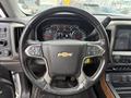 Steering wheel of a 2017 Chevrolet Silverado 1500 with controls and a Chevrolet logo prominently displayed