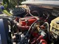 Close-up of the engine compartment of a 2012 Freightliner M2 106 featuring red engine components and various hoses and wires