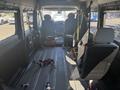 Interior view of a 2020 RAM ProMaster 3500 featuring two front seats and a spacious cargo area with floor tracks and various mounting points for equipment