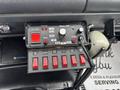 A control panel featuring various switches and buttons for emergency lights and sirens in a 2002 GMC C7500 vehicle