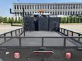 A black 2005 GMC C7500 Topkick flatbed truck with a metal mesh bed and an orange light on the cab roof