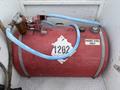 A red diesel fuel tank with a filling nozzle and blue hoses attached labeled diesel fuel only and marked with the number 1202