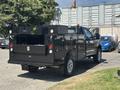 A black 2022 Ford F-350 SD with a utility bed features multiple storage compartments and is equipped with lights and a hitch at the rear