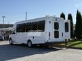 A white 2015 Ford Econoline van with a wheelchair access door open and multiple windows on its side