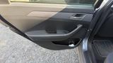 A 2018 Hyundai Sonata door interior featuring a black handle and control panel for windows with a cup holder below