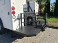 A 2005 Freightliner M2 106 truck with a flatbed and step ladder attached at the rear designed for easy access and equipment loading