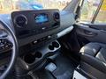 Interior view of a 2023 Mercedes-Benz Sprinter 2500 featuring a modern dashboard with a digital display and multiple cupholders