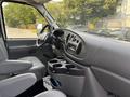 Interior view of a 2008 Ford Econoline showing the driver's seat dashboard and center console with cup holders