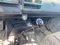 The interior of a 1996 GMC Top Kick featuring a manual gear shift with a round black knob and a textured boot