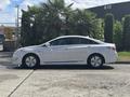 A 2014 Hyundai Sonata parked on a street viewed from the side showcasing its sleek design and silver color