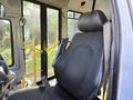 A 2017 Chevrolet Express driver's seat with a black fabric covering and a safety belt attached