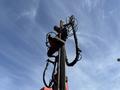 A 2018 Sandvik Ranger DX800 with an articulated drilling arm and hydraulic hoses extended upward against a blue sky