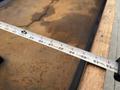 A measuring tape extended across a surface showing markings for measurements up to 12 feet with varying increments visible