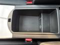 A top-down view of a black storage compartment in a 2013 BMW X3 with textured bottom and a small rectangular section on the right side