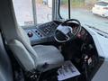 Interior view of a 2014 International 4300 truck showing the driver's seat steering wheel and dashboard controls with gauges and buttons