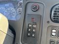 The interior control panel of a 2006 Freightliner M2 106 featuring a gear shift with buttons for various modes and digital displays for speed and fuel