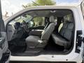 Interior view of a 2021 Ford F-150 showcasing front and rear seats in gray fabric with a center console and door open to reveal the spacious cabin