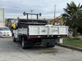 A 2015 Ford F-350 truck with a flatbed and rear compartment is positioned in the foreground