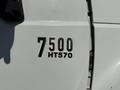 Close-up of a chrome emblem displaying the numbers 7500 and the letters HT570 on the side of a white International 7500 truck