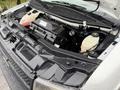 The image shows the open hood of a 2021 Chevrolet Express revealing the engine compartment with various components including the battery and fluid reservoirs