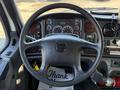 Interior view of a 2011 Freightliner M2 106 featuring a steering wheel dashboard with gauges and controls along with a key in the ignition and a thank you note on the floor