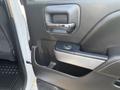 A close-up view of the door handle and window controls of a 2017 Chevrolet Silverado 1500 interior door panel