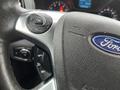 Close-up of the steering wheel of a 2017 Ford Transit Connect featuring control buttons and the Ford logo