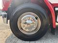 Close-up of a chrome wheel rim on a 1999 Freightliner FL80 truck featuring a Michelin tire with a six-bolt pattern and shiny lug nut covers
