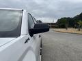 A 2016 GMC Sierra 1500 in white viewed from the driver's side showcasing the side mirror and part of the truck's body
