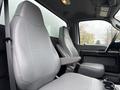 Interior view of a 2011 Ford F-650 showcasing two gray upholstered front seats and a center console with storage compartments