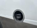 Close-up of a fuel fill nozzle on a 2020 Chevrolet Express with a black cap and a circular metal rim