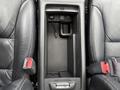An empty center console between two black leather seats in a 2014 Honda CR-V with storage compartments and a power outlet visible