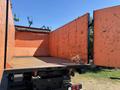 A 2016 Isuzu NPR-HD truck with an open cargo bed featuring orange walls and a wooden floor