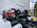 Close-up of a 2022 Lion Lion6 truck's engine compartment showing fluid reservoir and engine components in a white and black color scheme