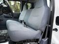 Interior view of a 2001 Ford F-350 with a gray bench seat featuring a textured fabric and armrest in the center